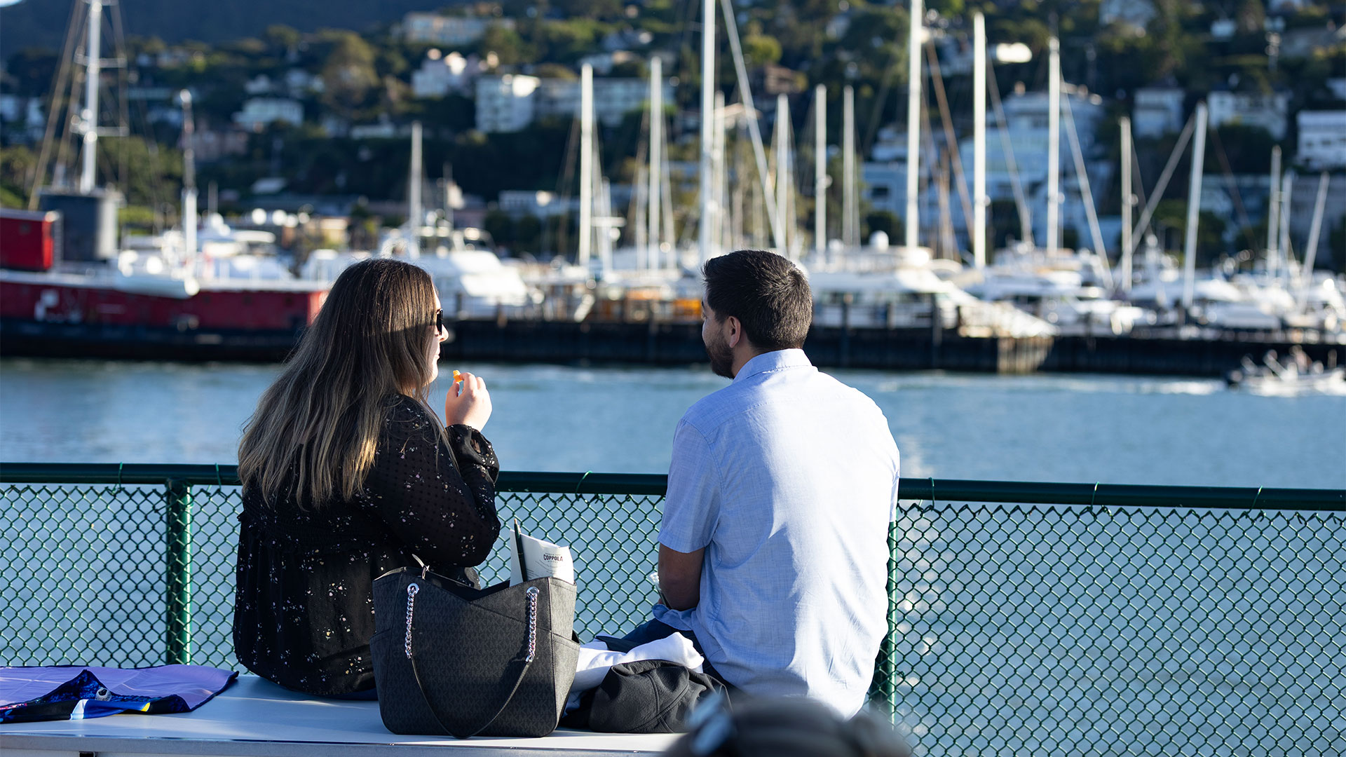 Two people enjoying a cruise in the San Francisco bay with a view of the marina