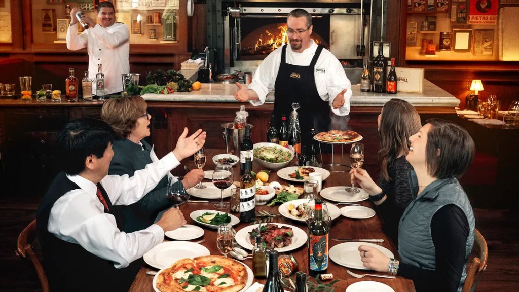 Chef at dinner table with wine and food