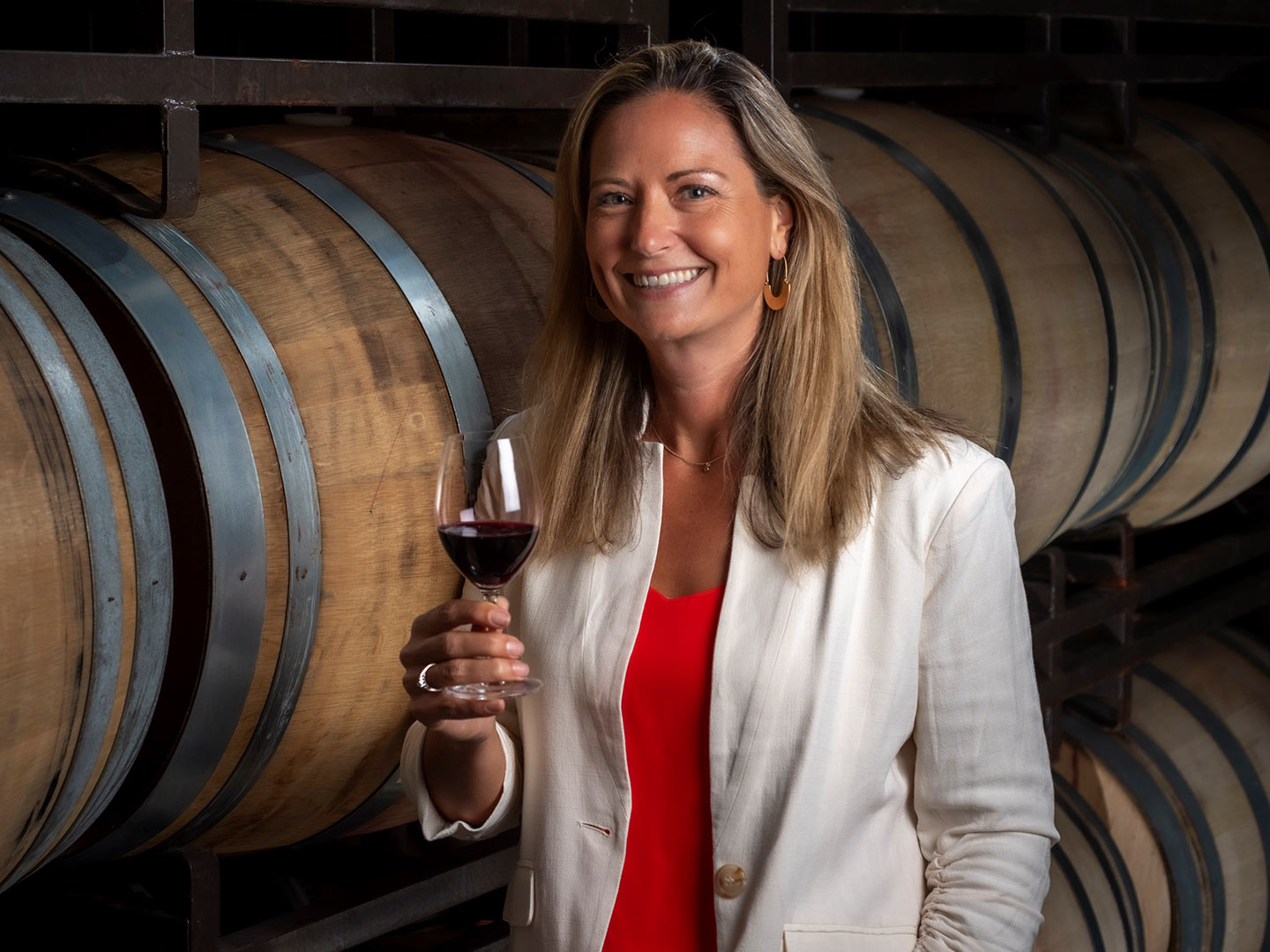 Winemaker Andrea Card, pictured in front of a stack of wine barrels