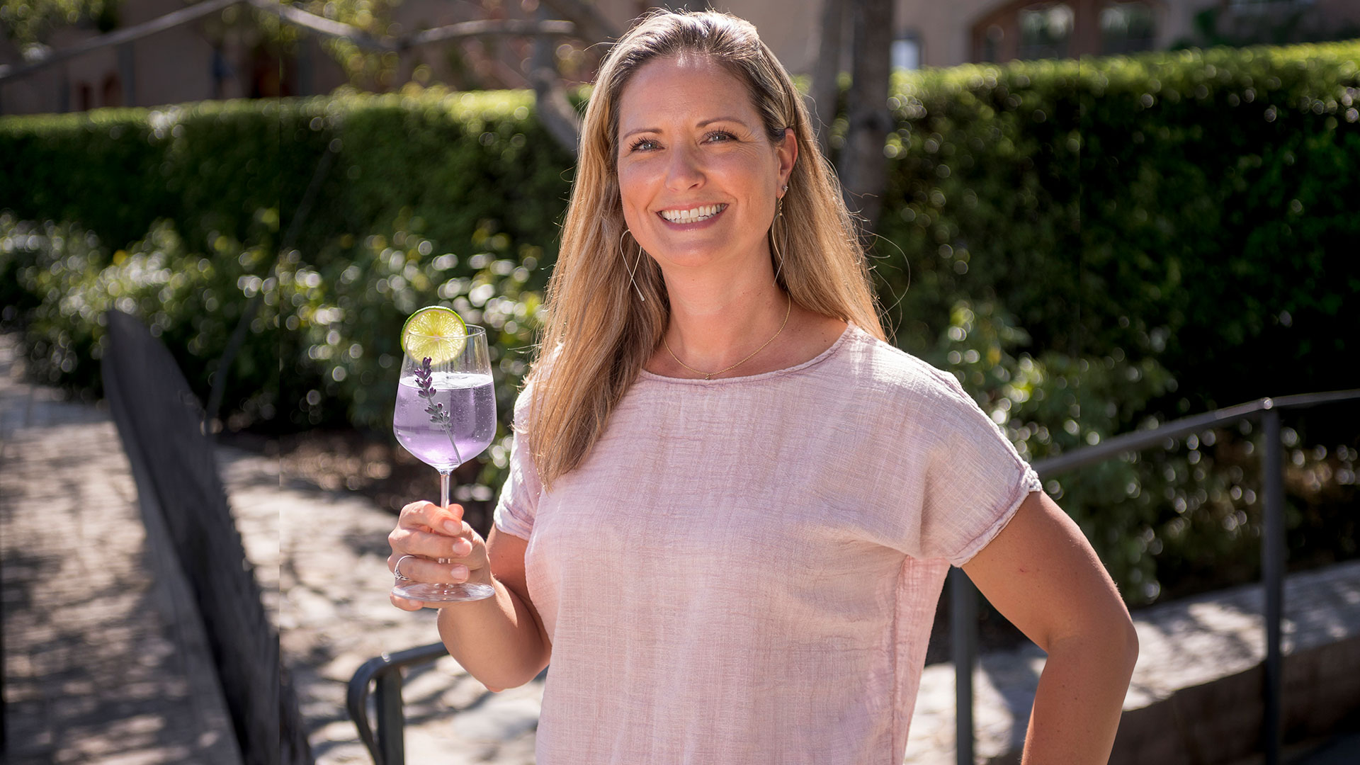 Winemaker Andrea Card pictured outdoors holding a glass of lavender lime spritz
