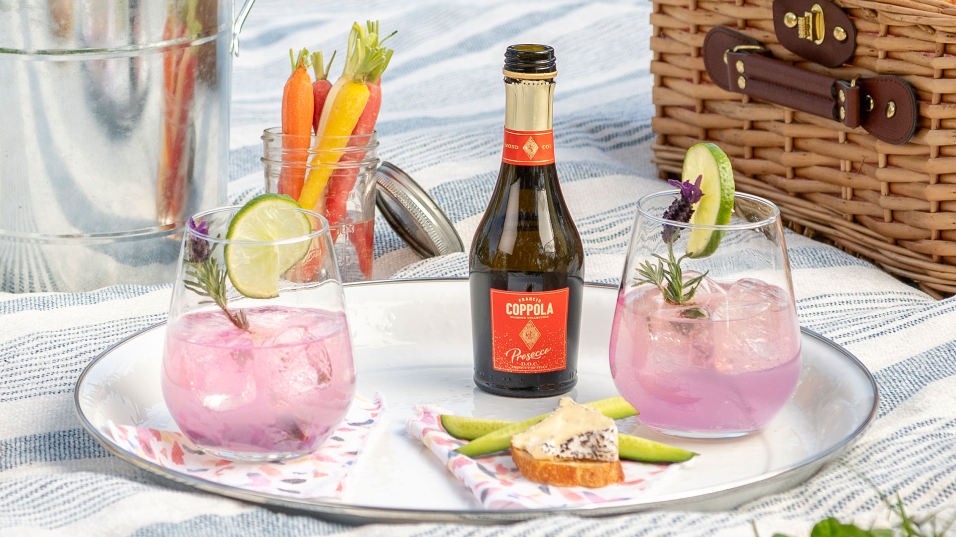 Coppola Diamond Collection Prosecco mini on a platter with 2 stemless wine glasses photographed on a picnic style blanket